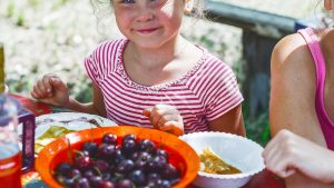 a little girl is going to eat in the fresh air